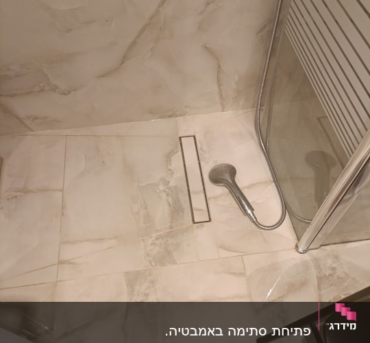 מקלחת עם ראש מקלחת ורצפת אריחים
